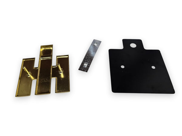 Three metal hardware components on a white background: two gold-toned bracket-like pieces, one small silver rectangular piece, and one black mounting plate with three holes.