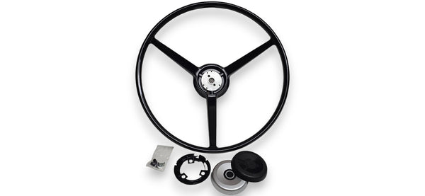A black three-spoke steering wheel shown on a white background, with mounting hardware and a center cap placed below it.