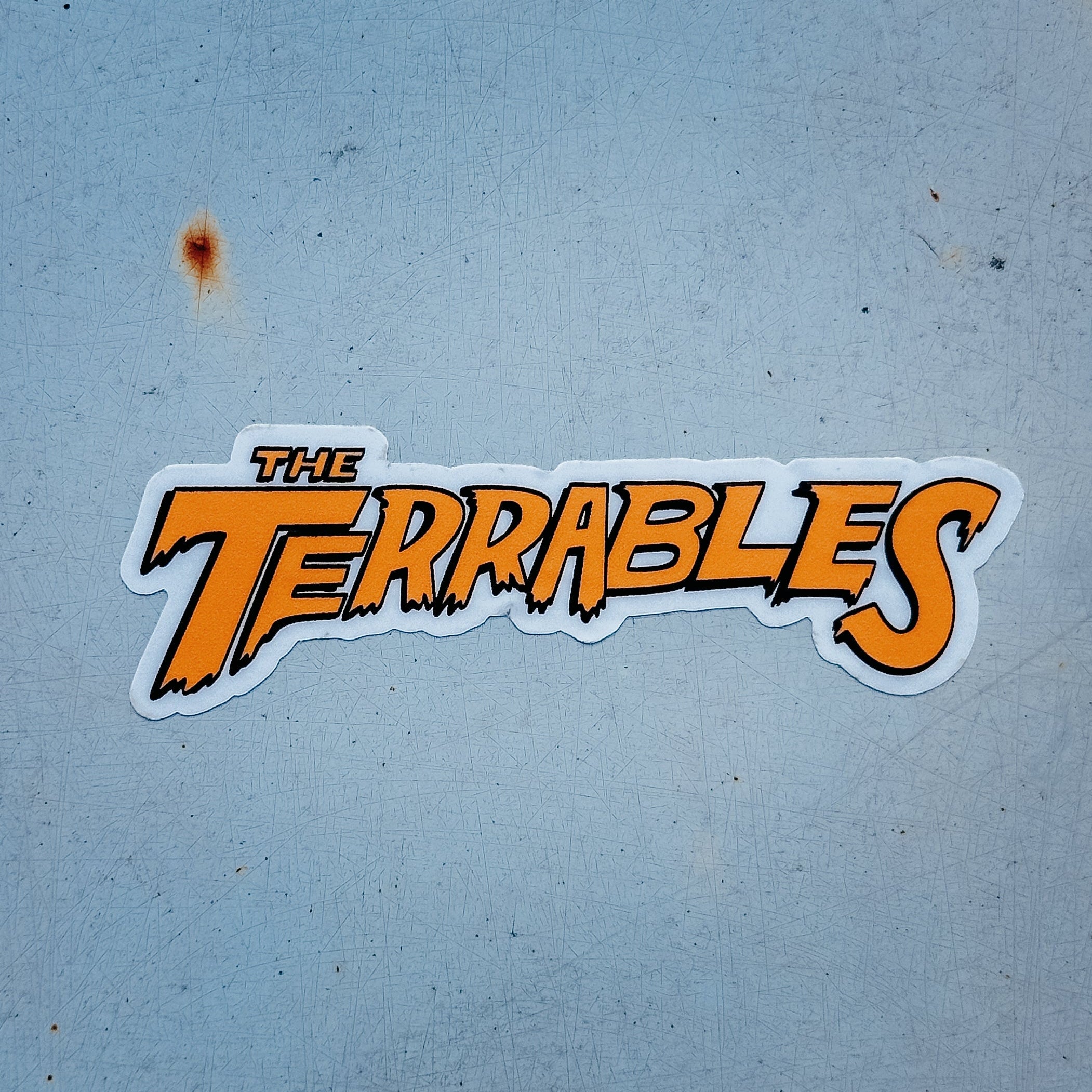 Sticker with 'The Terrables' text on a textured blue background
